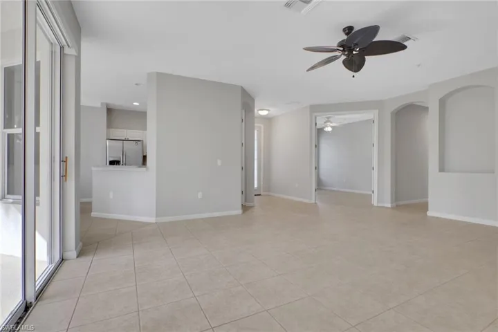 Living room with view of kitchen, front door, and den