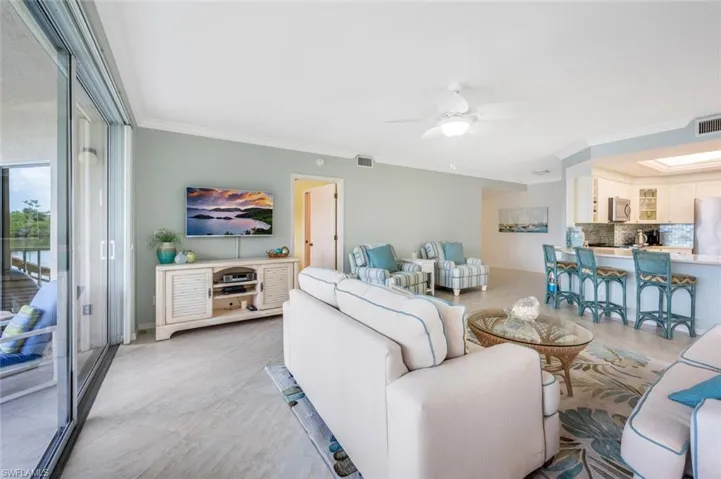 Living area with ornamental molding and ceiling fan