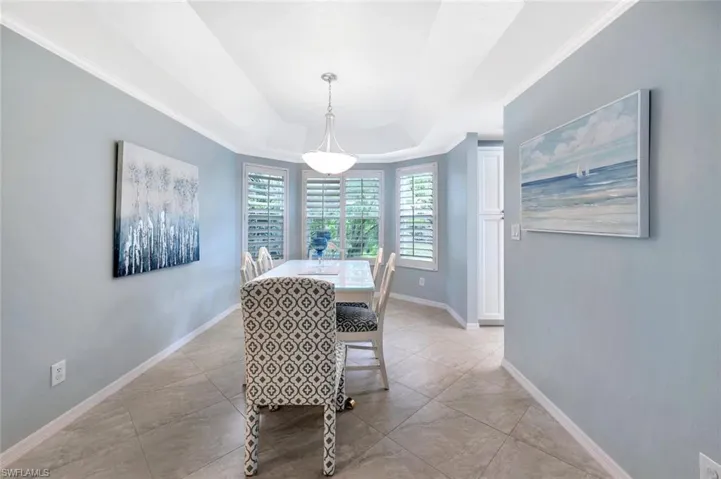 Dining room with a tray ceiling and ornamental molding