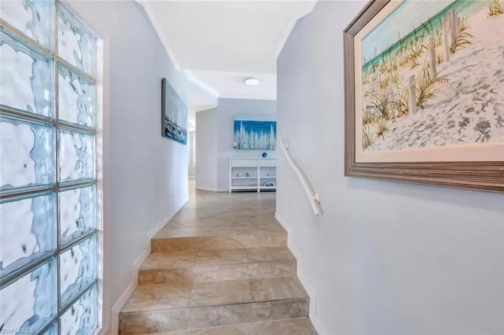 Corridor with baseboards and crown molding