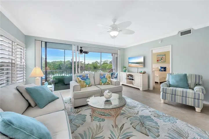 Tiled living room featuring crown molding and ceiling fan