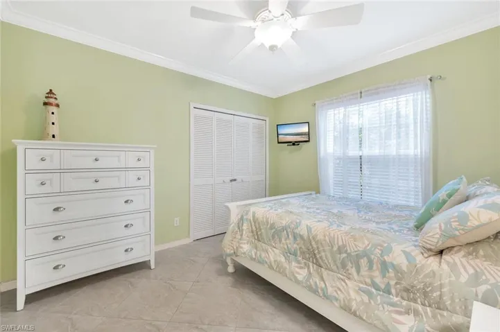 Bedroom with crown molding, a ceiling fan, and a closet