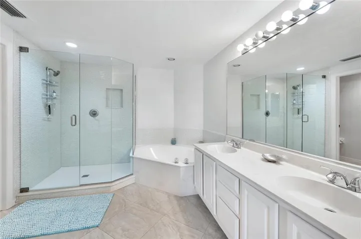 Full bath with a garden tub, a shower stall, double vanity, light tile patterned flooring, and recessed lighting