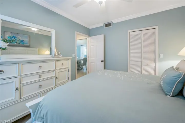 Bedroom with ornamental molding, ceiling fan, and a closet