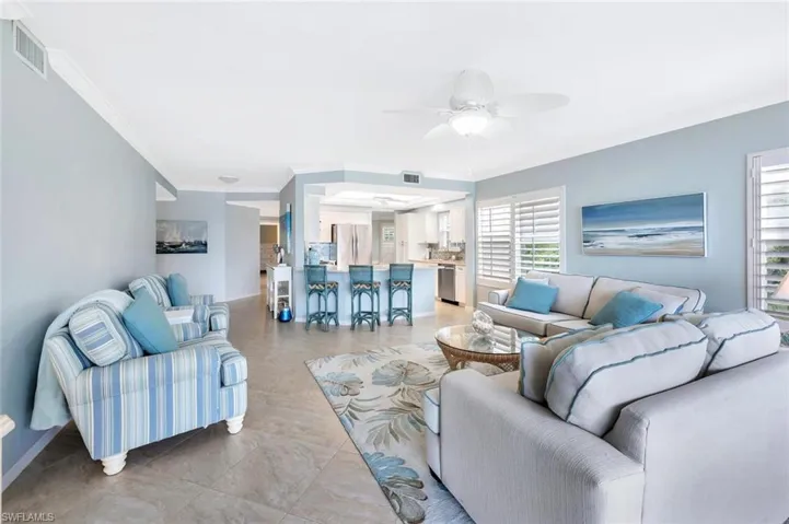 Living area with a ceiling fan and crown molding
