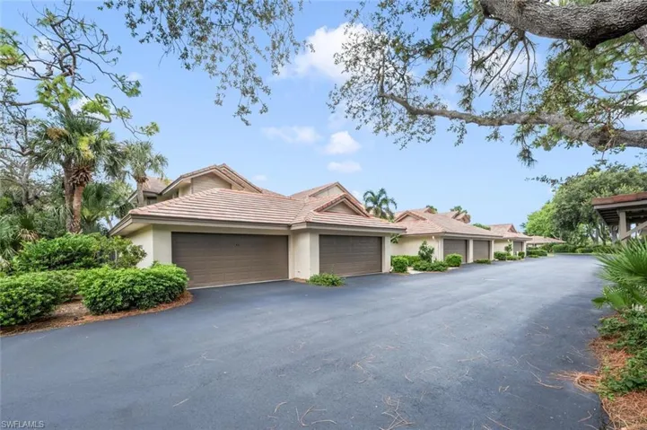 View of front of property with stucco siding, a tiled roof, and asphalt driveway