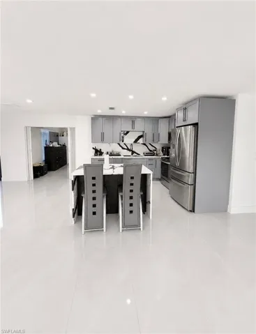 Open-concept kitchen with light gray cabinetry, stainless steel appliances, and a central island