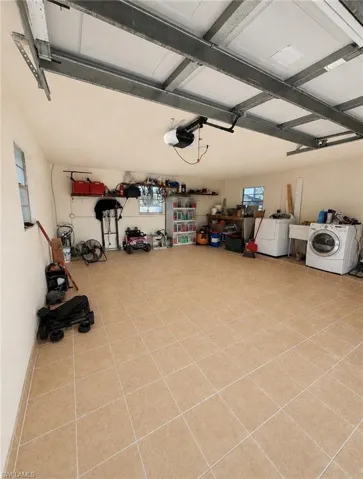 Tiled flooring, built-in shelving, two windows, automatic garage door opener, and overhead garage door track system