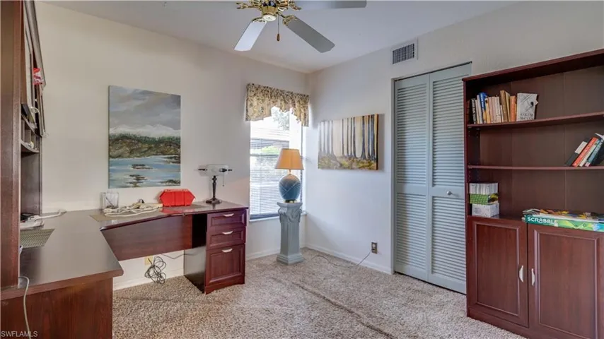 Carpeted home office featuring ceiling fan