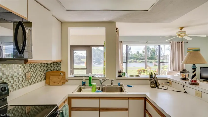 Kitchen featuring white cabinetry, a healthy amount of sunlight, tasteful backsplash, and sink