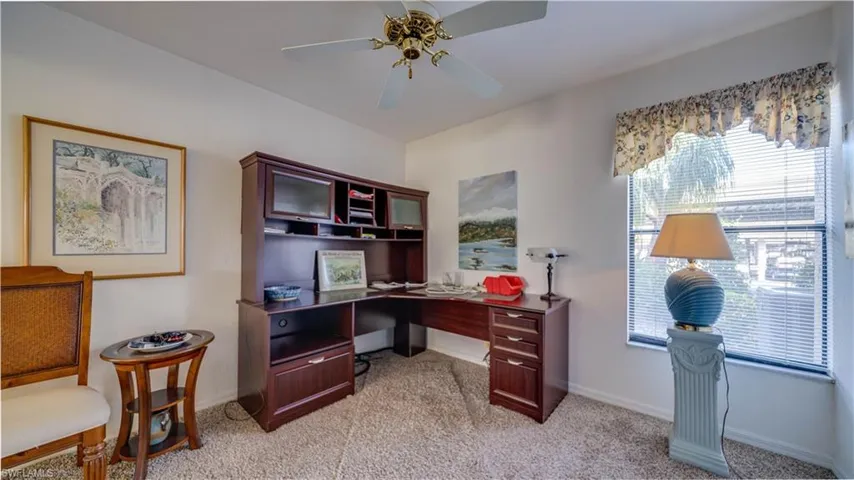 Home office with light carpet and ceiling fan