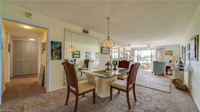 Dining room featuring carpet and ceiling fan with notable chandelier