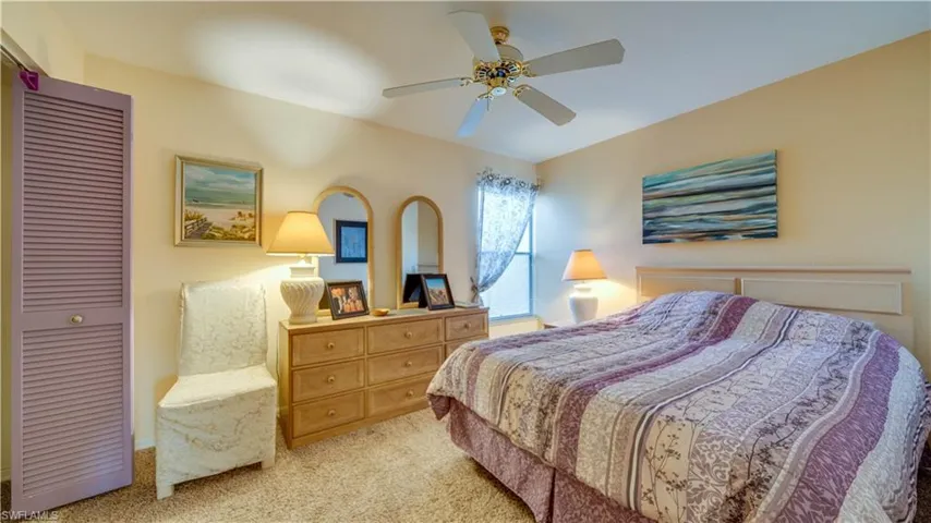 Bedroom with a closet, ceiling fan, and light colored carpet