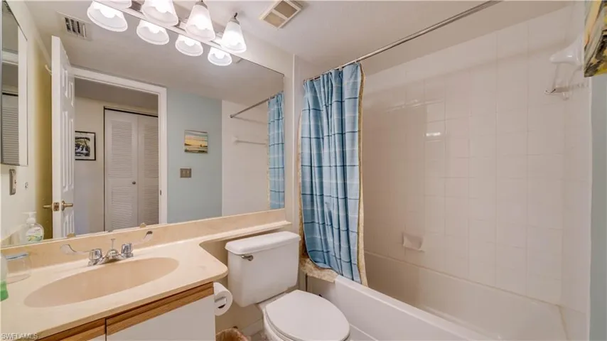 Full bathroom featuring vanity, shower / bath combination with curtain, and toilet