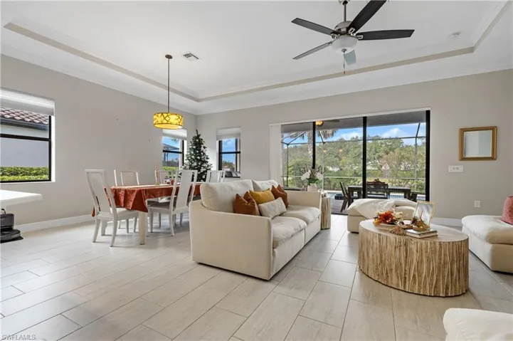 Living area featuring a raised ceiling and crown molding