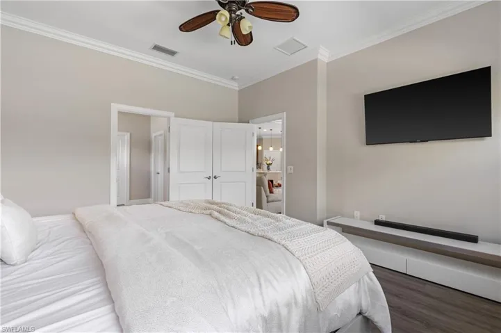 Bedroom featuring crown molding, wood finished floors, and ceiling fan