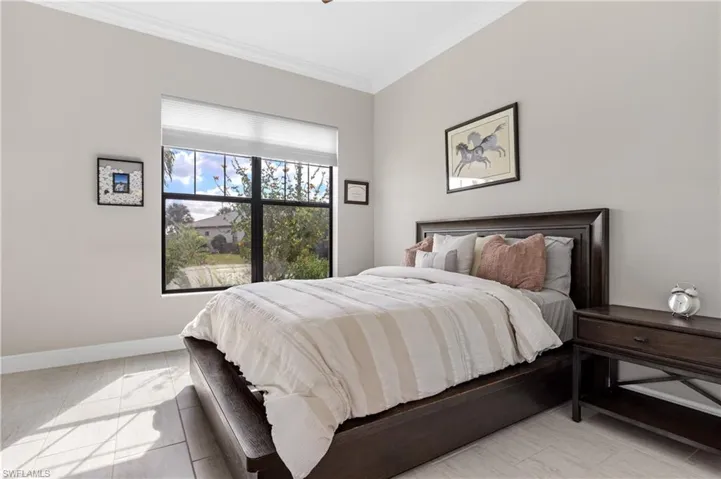 Bedroom with crown molding and baseboards