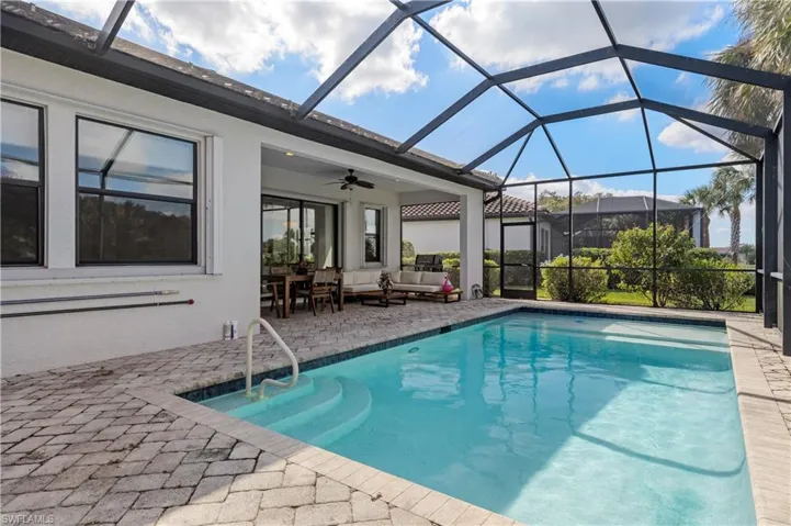 Swimming pool with a sunroom, a lanai, an outdoor hangout area, a patio area, and ceiling fan