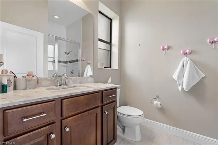 Bathroom featuring vanity, a shower stall, and light tile patterned flooring
