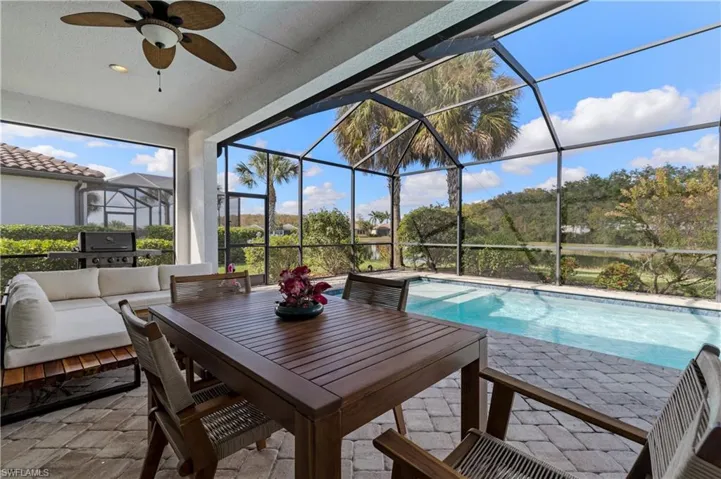 Sunroom / solarium featuring a ceiling fan, an outdoor living space, and a patio area