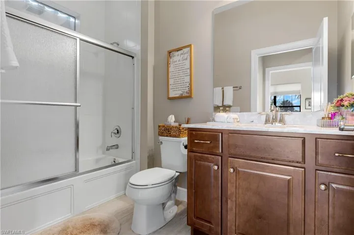 Bathroom featuring combined bath / shower with glass door and vanity
