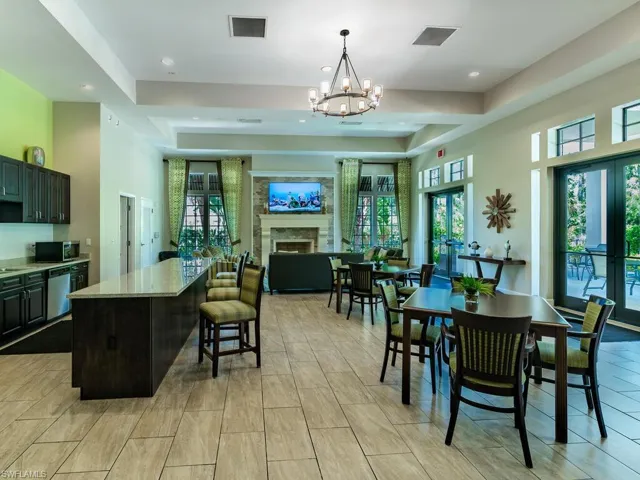 Dining room with french doors, a towering ceiling, a chandelier, light tile floors, and a raised ceiling