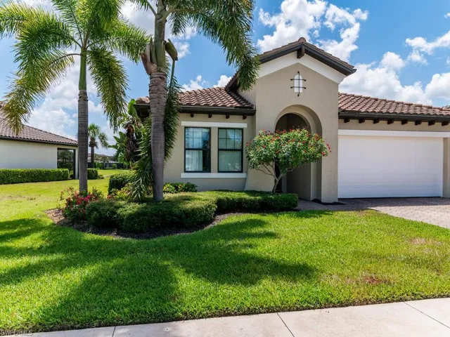 Mediterranean / spanish house with a front yard and a garage