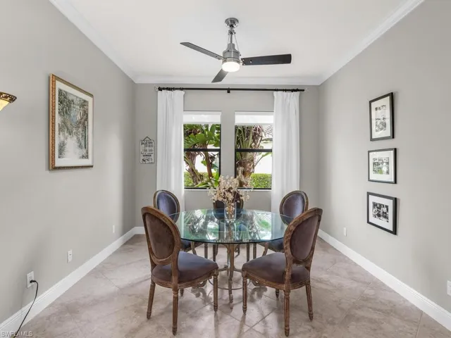 Dining area featuring ornamental molding, light tile patterned floors, and ceiling fan