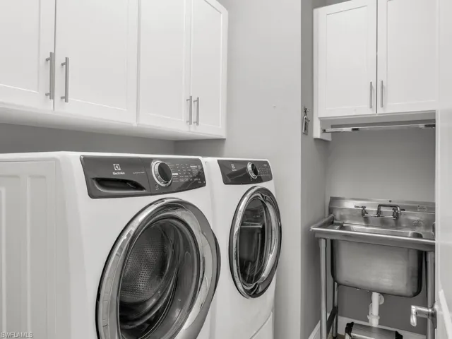 Laundry room with cabinets, sink, and washing machine and dryer