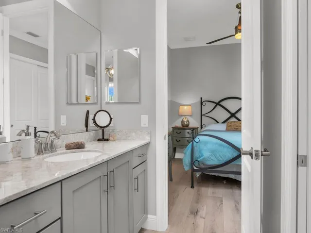 Bathroom with crown molding, ceiling fan, hardwood / wood-style floors, and oversized vanity