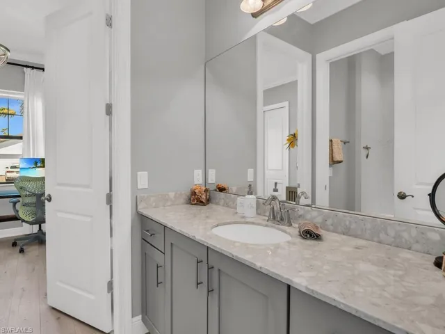 Bathroom featuring crown molding, vanity, and hardwood / wood-style floors