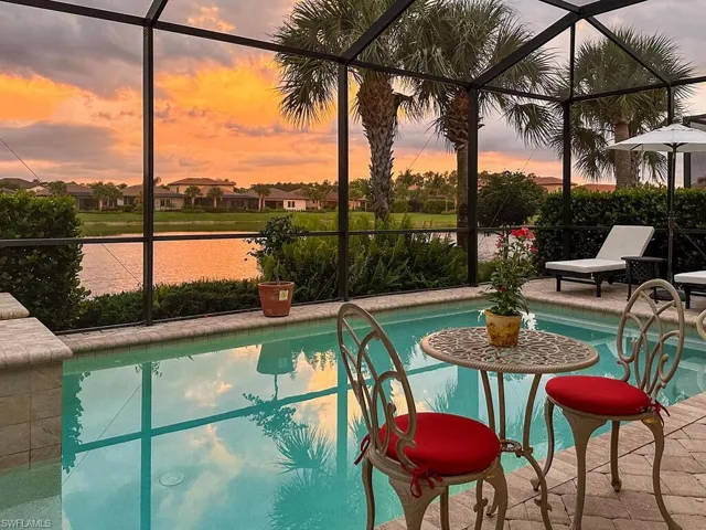 Pool at dusk featuring a patio and a lanai