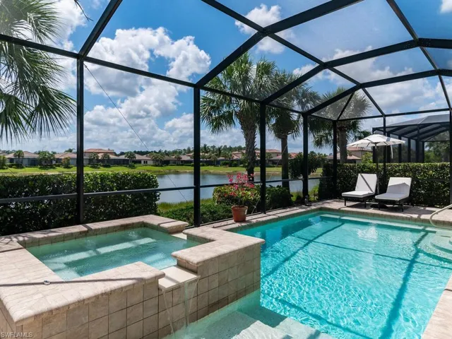 View of pool with a lanai and an in ground hot tub