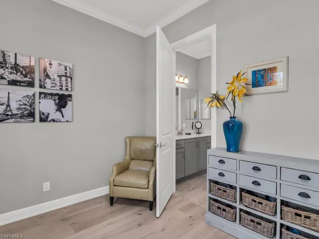 Sitting room with light hardwood / wood-style floors and crown molding