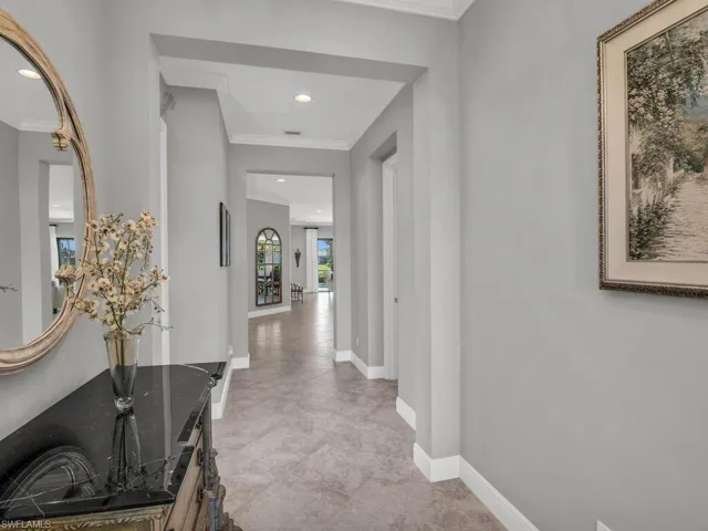 Hallway featuring crown molding and light tile floors