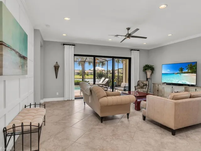 Tiled living room featuring ceiling fan and crown molding