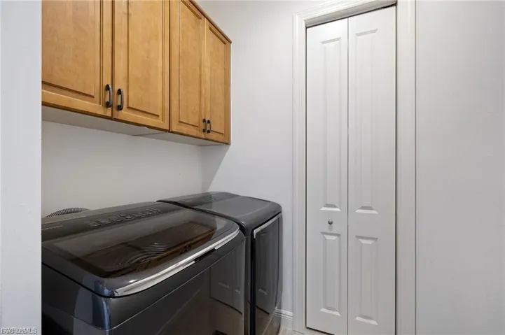 Laundry room with separate washer and dryer and cabinet space
