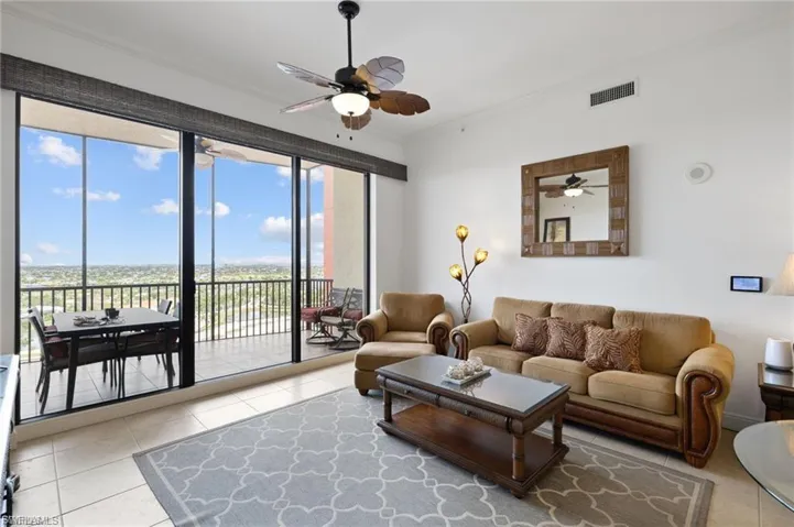 Living room with crown molding and a ceiling fan