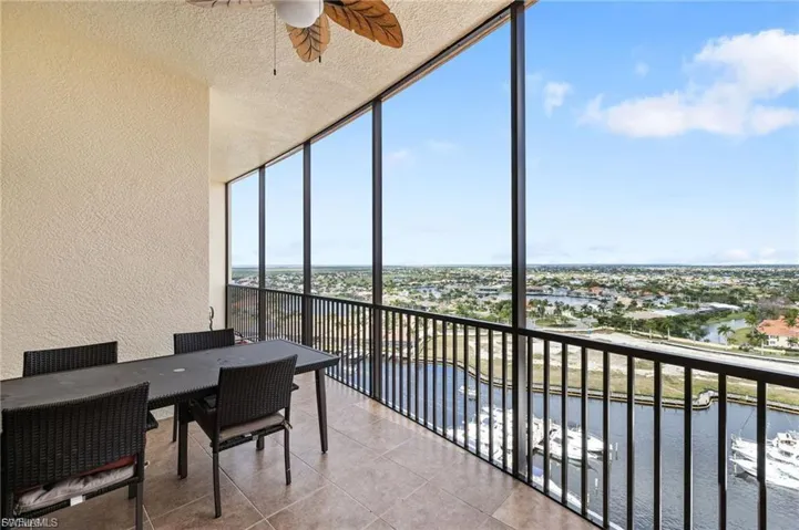 Sunroom / solarium featuring ceiling fan, a balcony, a water view, and outdoor dining space