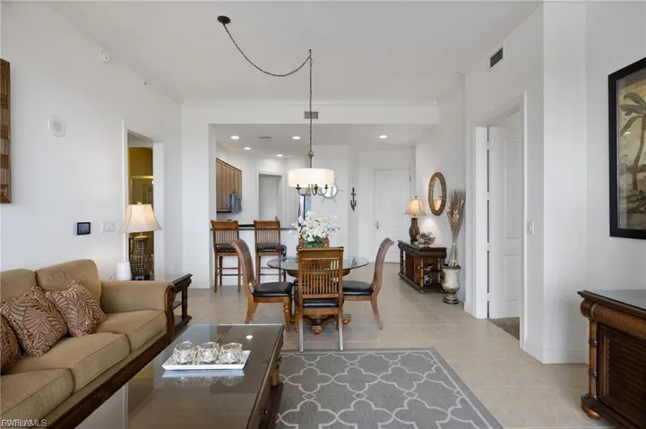Living area featuring crown molding, light tile patterned floors, and a chandelier