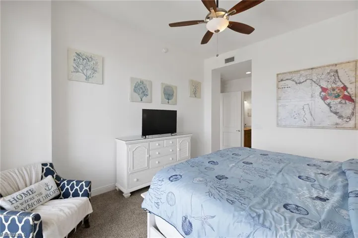 Carpeted bedroom featuring a ceiling fan and baseboards