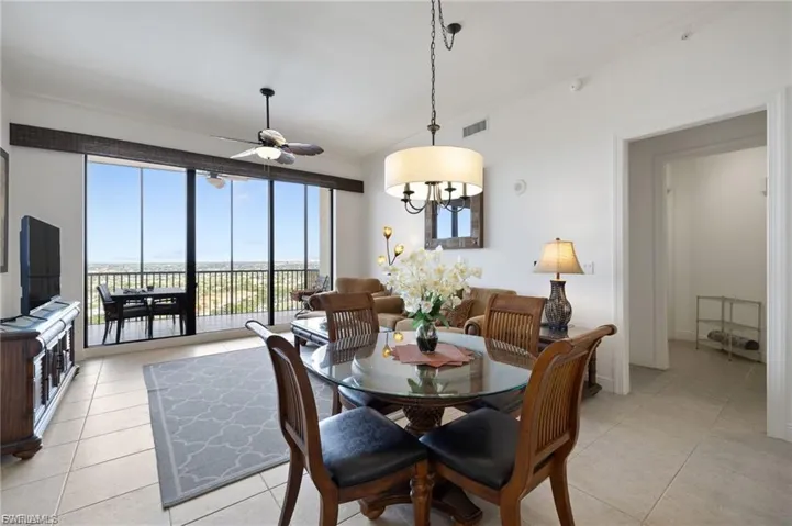 Tiled dining space featuring ceiling fan and crown molding