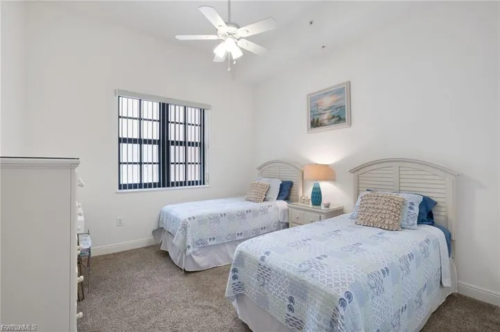 Carpeted bedroom featuring a ceiling fan and baseboards