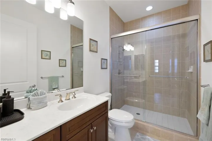 Full bathroom with vanity, a shower stall, and recessed lighting