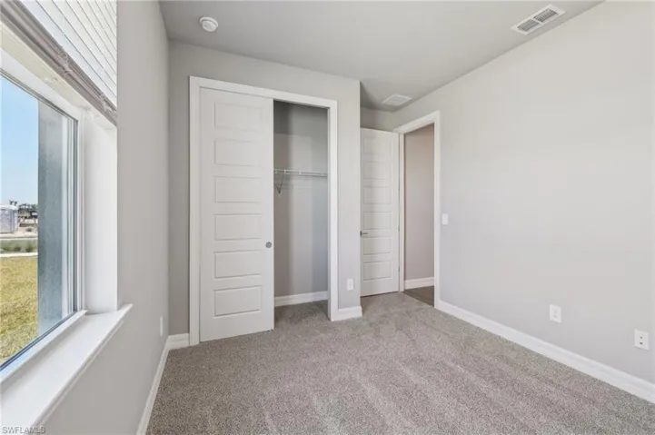 Unfurnished bedroom featuring carpet, a closet, and baseboards