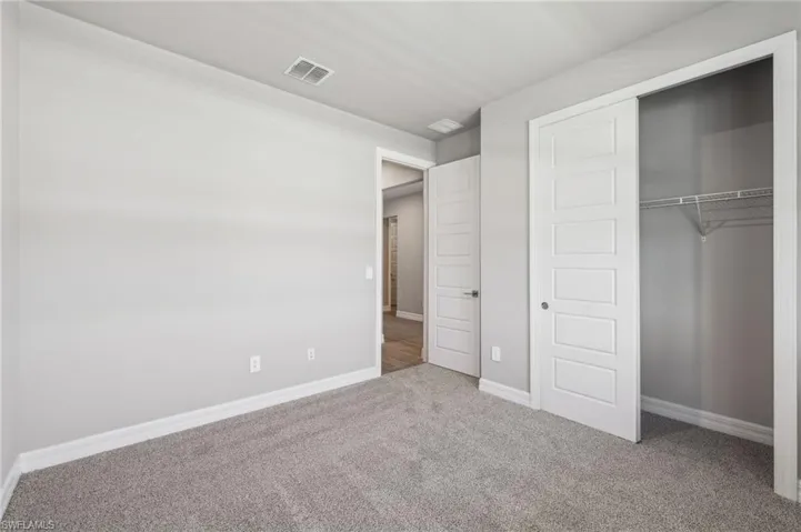 Unfurnished bedroom with carpet floors, a closet, and baseboards