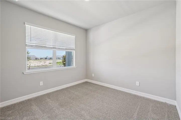 Empty room with carpet floors and baseboards