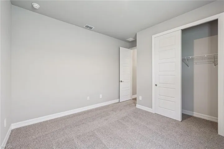 Unfurnished bedroom featuring carpet flooring, a closet, and baseboards