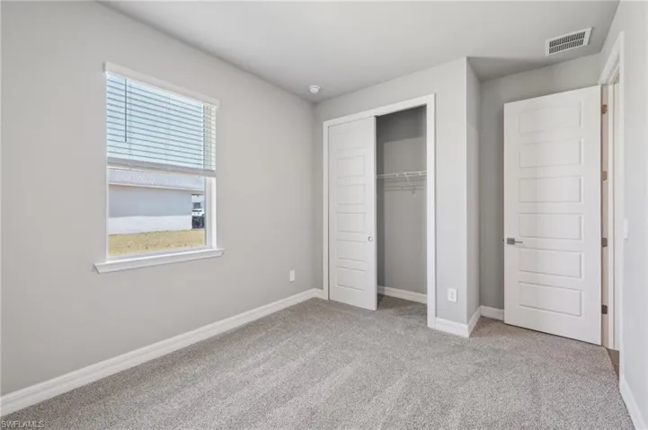 Unfurnished bedroom with carpet floors, a closet, and baseboards
