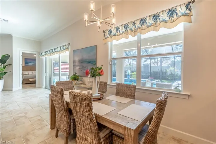 Dining space featuring ornamental molding, a chandelier, and healthy amount of natural light
